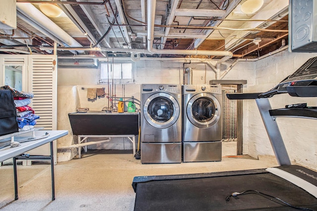 washroom with a sink, laundry area, and washer and clothes dryer