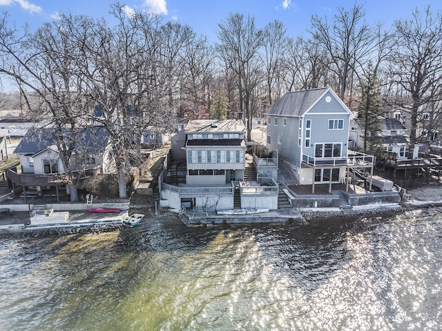 back of property featuring a deck with water view, stairway, and a residential view