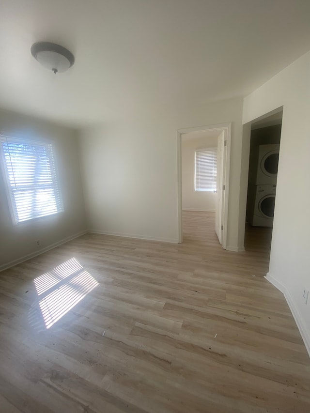 20746 Westland Dr, Southfield, MI 48075 - empty room featuring baseboards, light wood-style floors, and stacked washing maching and dryer