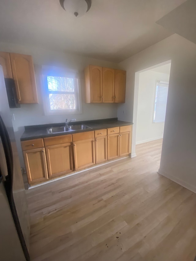 20746 Westland Dr, Southfield, MI 48075 - kitchen with freestanding refrigerator, a sink, dark countertops, and light wood-type flooring