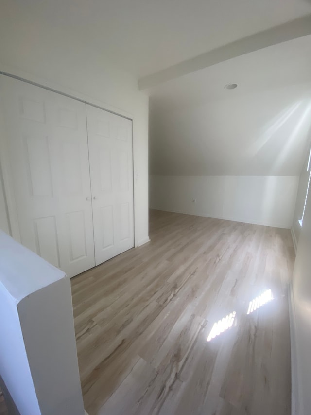 20746 Westland Dr, Southfield, MI 48075 - unfurnished bedroom with lofted ceiling, a closet, and wood finished floors