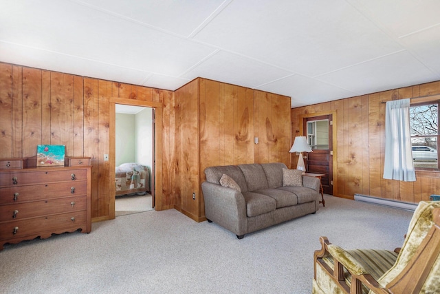 carpeted living area with a baseboard heating unit and wooden walls