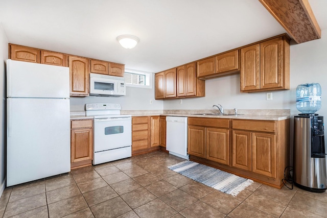 kitchen featuring light countertops, white appliances, tile patterned floors, a sink, and brown cabinetry