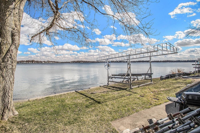 view of dock with a lawn, a water view, and boat lift