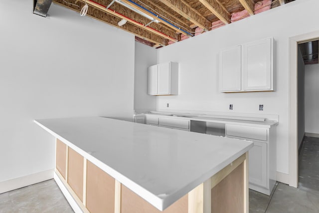 215 Nottingham Dr, Brooklyn, MI 49230 - kitchen featuring light countertops, concrete floors, and white cabinets