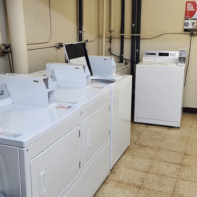 community laundry room with washer and dryer and a textured wall