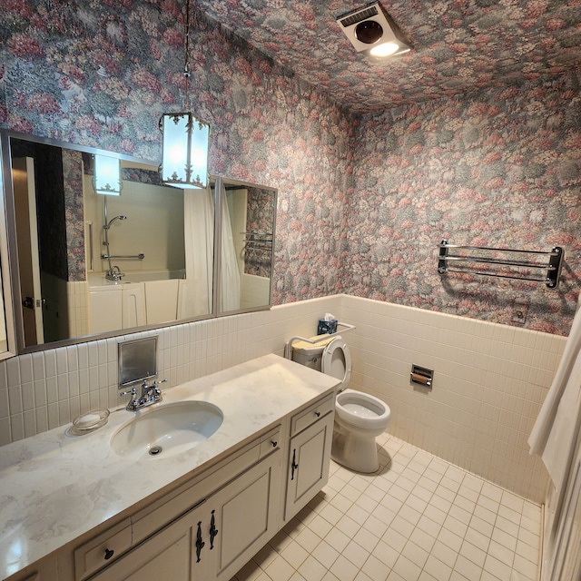 full bathroom featuring vanity, wallpapered walls, tile patterned flooring, toilet, and a wainscoted wall