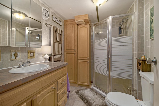 full bathroom featuring tile walls, toilet, vanity, and a shower stall