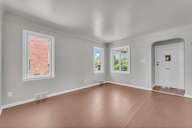 17189 Albion Ave, Detroit, MI 48234 - empty room with baseboards, arched walkways, visible vents, and wood finished floors