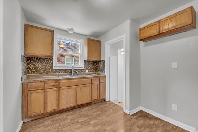 17189 Albion Ave, Detroit, MI 48234 - kitchen with baseboards, light wood finished floors, a sink, and tasteful backsplash