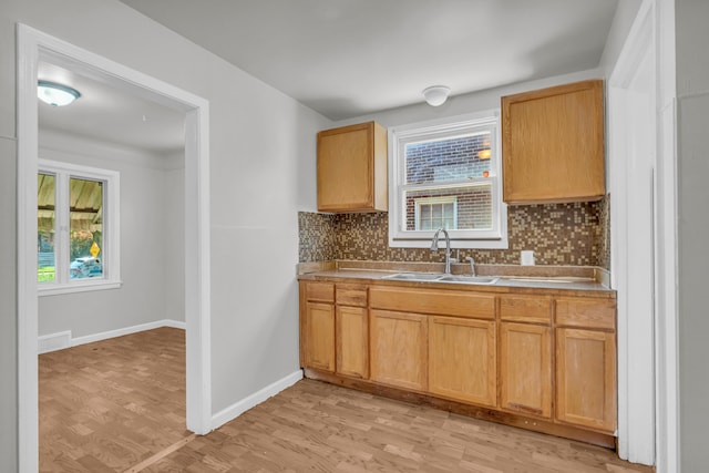 17189 Albion Ave, Detroit, MI 48234 - kitchen with decorative backsplash, a sink, light wood-type flooring, and plenty of natural light