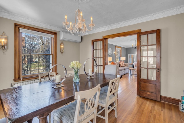 1515 W Franklin St, Jackson, MI 49203 - dining room featuring crown molding, baseboards, light wood-style floors, an inviting chandelier, and an AC wall unit