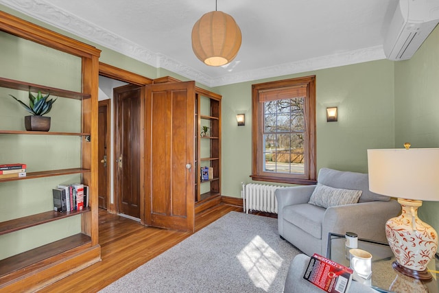 1515 W Franklin St, Jackson, MI 49203 - living area with radiator, a wall mounted AC, wood finished floors, and ornamental molding