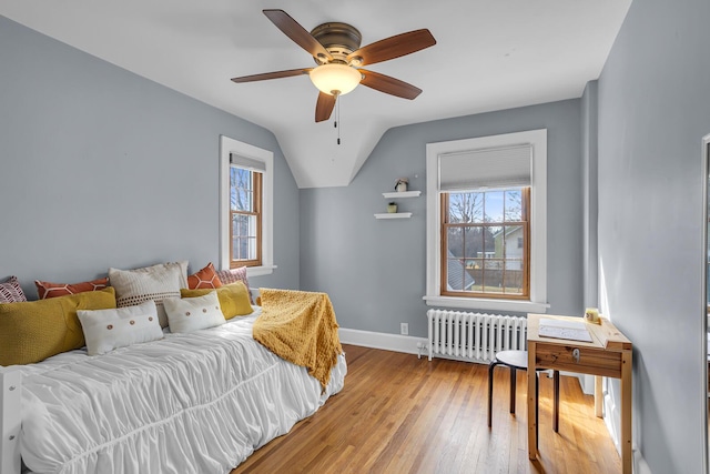 1515 W Franklin St, Jackson, MI 49203 - bedroom with vaulted ceiling, radiator, baseboards, ceiling fan, and hardwood / wood-style floors