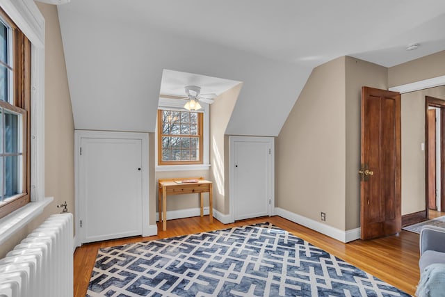 1515 W Franklin St, Jackson, MI 49203 - interior space with baseboards, lofted ceiling, radiator heating unit, and light wood finished floors