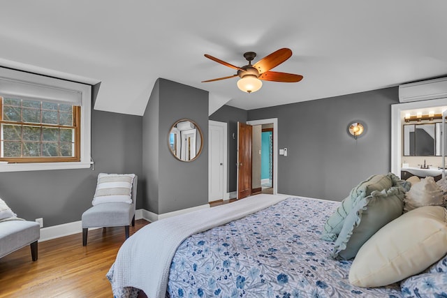 1515 W Franklin St, Jackson, MI 49203 - bedroom featuring connected bathroom, a ceiling fan, wood finished floors, a wall mounted air conditioner, and baseboards