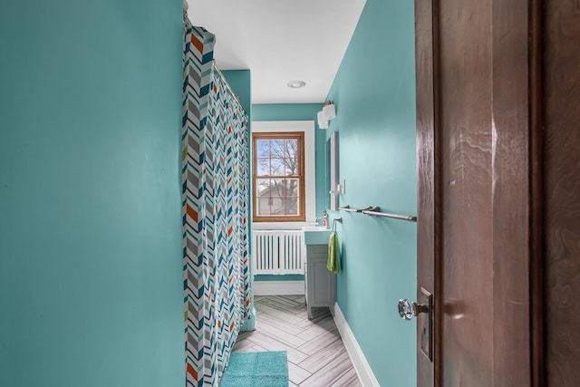 1515 W Franklin St, Jackson, MI 49203 - full bathroom with baseboards, radiator heating unit, and curtained shower