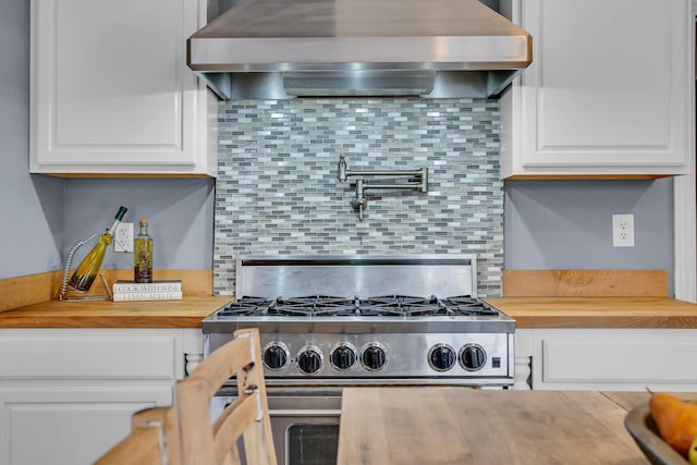 1515 W Franklin St, Jackson, MI 49203 - kitchen featuring wooden counters, stainless steel stove, decorative backsplash, and wall chimney range hood