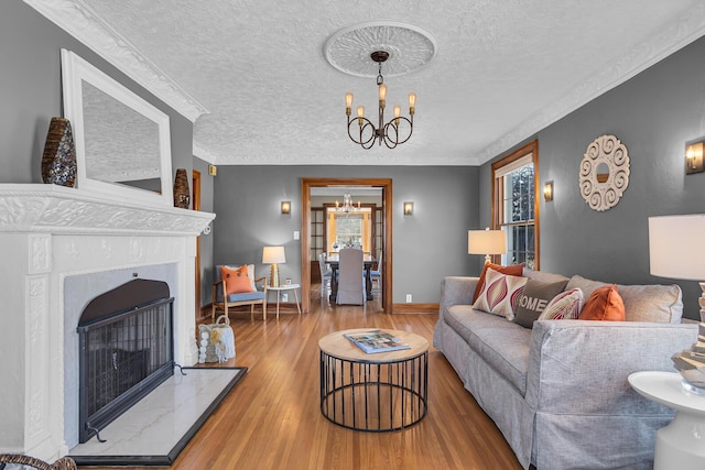 1515 W Franklin St, Jackson, MI 49203 - living room with a chandelier, wood finished floors, a fireplace with raised hearth, a textured ceiling, and ornamental molding