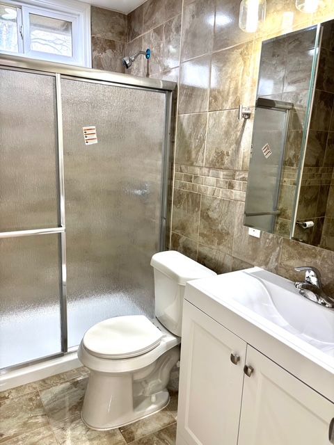 35030 Michelle Dr, Romulus, MI 48174 - full bath featuring tile walls, toilet, a stall shower, and vanity
