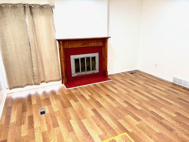 35030 Michelle Dr, Romulus, MI 48174 - unfurnished living room featuring visible vents, baseboards, and wood finished floors