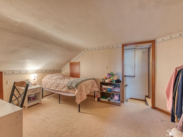 carpeted bedroom featuring baseboards, wallpapered walls, and vaulted ceiling