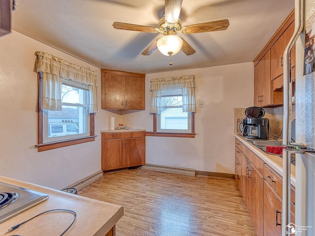 kitchen with plenty of natural light, brown cabinets, light countertops, and light wood-style floors