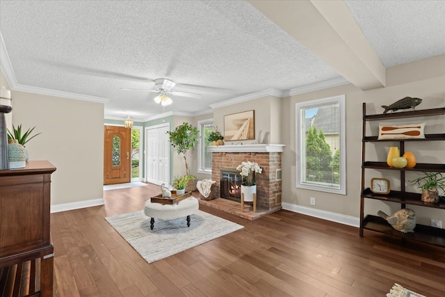 3155 Ridge Rd, White Lake, MI 48383 - living area featuring a textured ceiling, baseboards, dark wood-type flooring, a brick fireplace, and ceiling fan