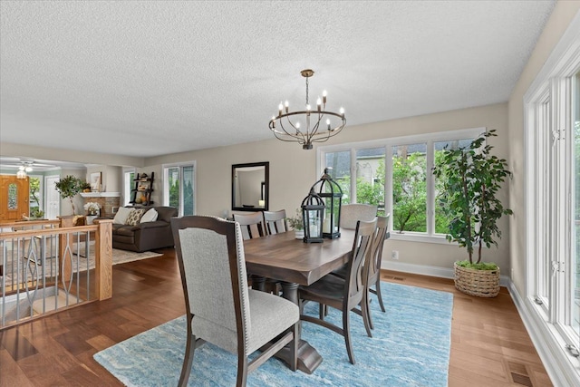 3155 Ridge Rd, White Lake, MI 48383 - dining space with a textured ceiling, a chandelier, wood finished floors, and baseboards
