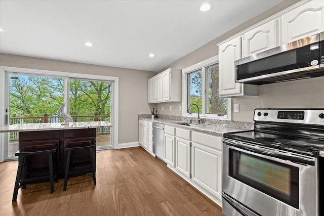 3155 Ridge Rd, White Lake, MI 48383 - kitchen featuring stainless steel appliances, a sink, plenty of natural light, white cabinetry, and recessed lighting