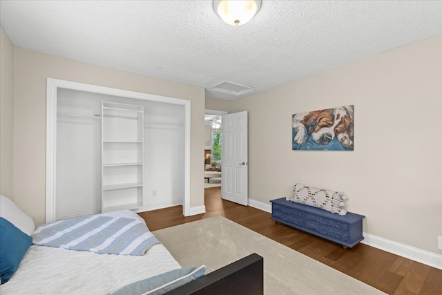 3155 Ridge Rd, White Lake, MI 48383 - bedroom with a closet, wood finished floors, baseboards, attic access, and a textured ceiling
