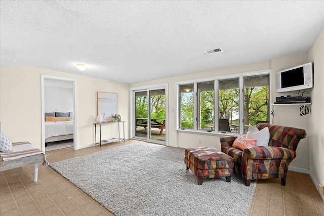 3155 Ridge Rd, White Lake, MI 48383 - living area with a textured ceiling, light tile patterned floors, and baseboards