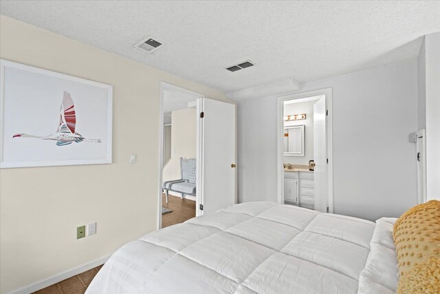 3155 Ridge Rd, White Lake, MI 48383 - bedroom with baseboards, dark tile patterned floors, a textured ceiling, and ensuite bath