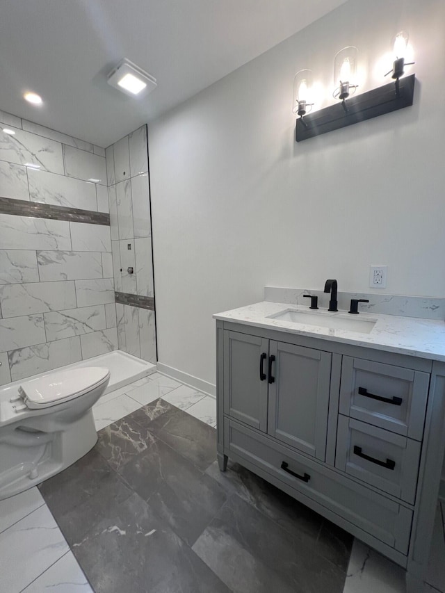 bathroom featuring marble finish floor, vanity, toilet, and tiled shower