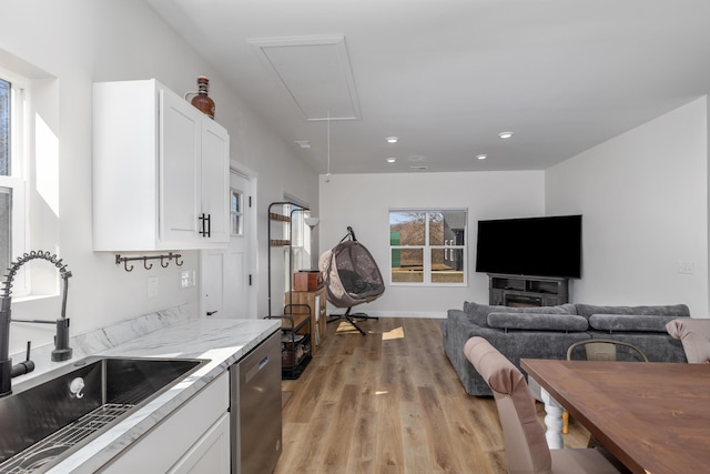 2084 W Fenwick Rd, Fenwick, MI 48834 - kitchen featuring stainless steel dishwasher, a sink, white cabinets, light wood finished floors, and open floor plan