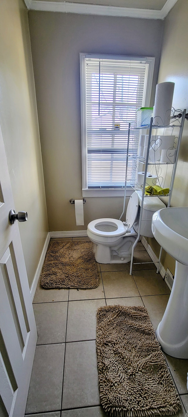 bathroom featuring plenty of natural light, tile patterned floors, toilet, and crown molding