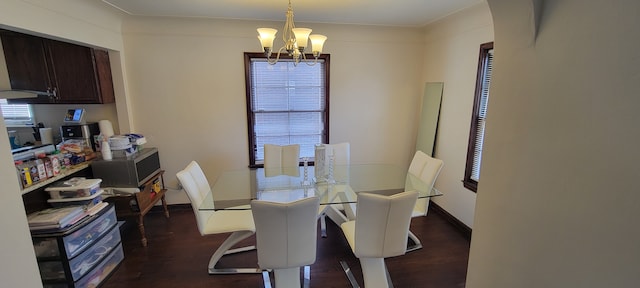 dining room with a chandelier, wood finished floors, arched walkways, and baseboards