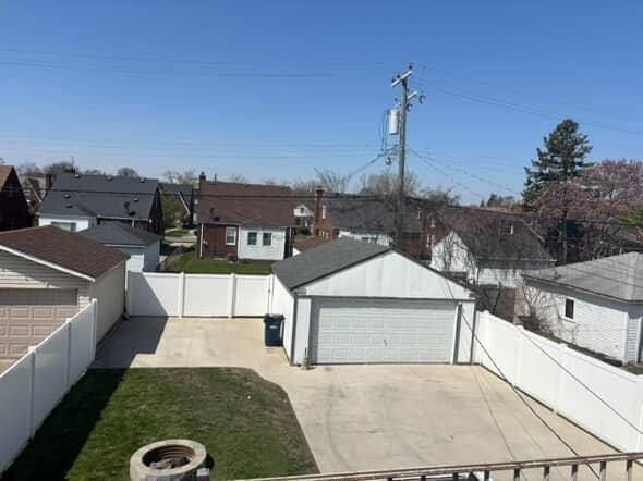 view of yard with a residential view, an outbuilding, and a detached garage
