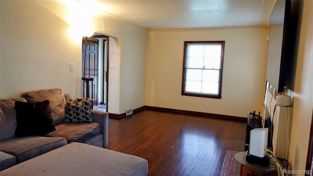 18229 Littlefield St, Detroit, MI 48235 - living area with arched walkways, dark wood-style floors, and baseboards