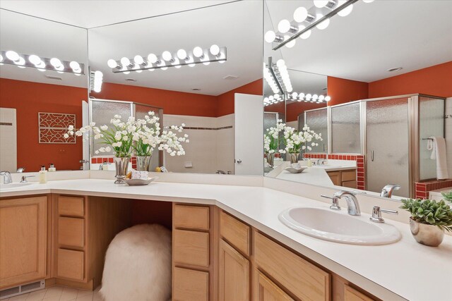 bathroom with a sink, a stall shower, and visible vents
