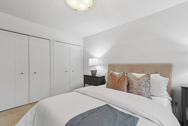 carpeted bedroom featuring multiple closets
