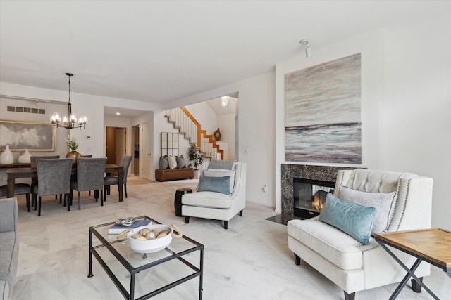 living room with stairway, a chandelier, visible vents, a high end fireplace, and light carpet