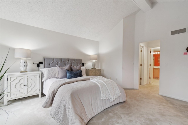 bedroom featuring baseboards, a textured ceiling, beam ceiling, visible vents, and light carpet