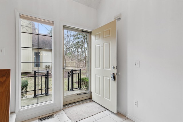 entrance foyer featuring baseboards, visible vents, and light tile patterned floors