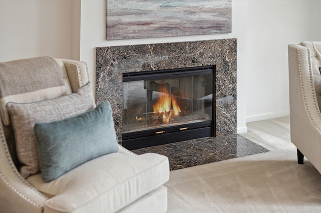 sitting room with baseboards, a high end fireplace, and carpet flooring