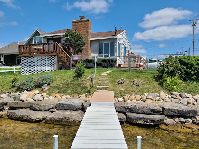 back of property with stairs, a chimney, a deck, fence, and a yard