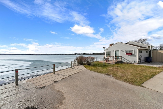 exterior space featuring a water view, fence, and a yard