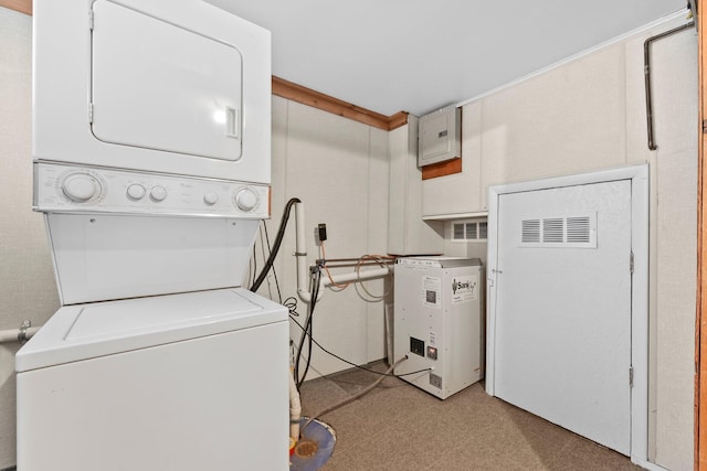 clothes washing area featuring a heating unit, laundry area, and stacked washer / drying machine