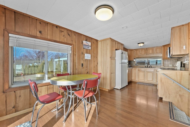 dining space with dark wood-style floors and wooden walls