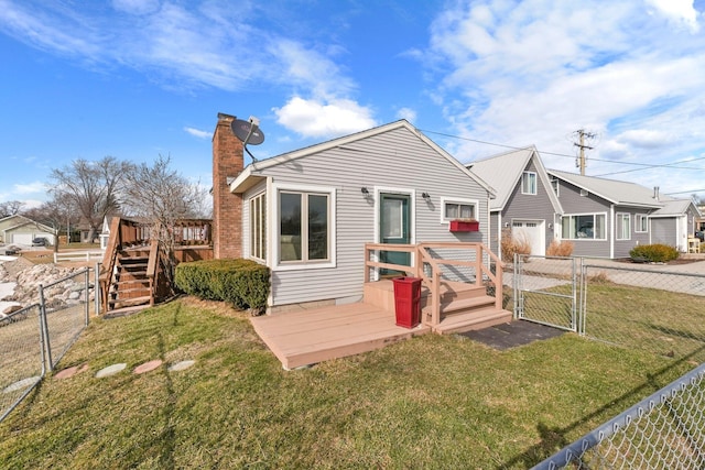 rear view of house with a gate, a garage, a deck, a lawn, and fence private yard